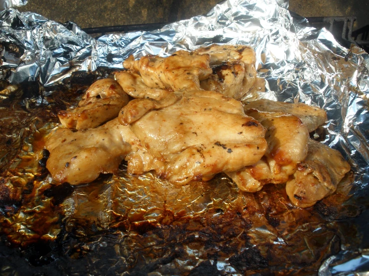 a chicken meal sitting on aluminum foil in a frying pan