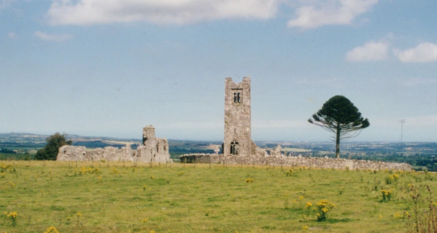 an old tower on top of a hill with trees