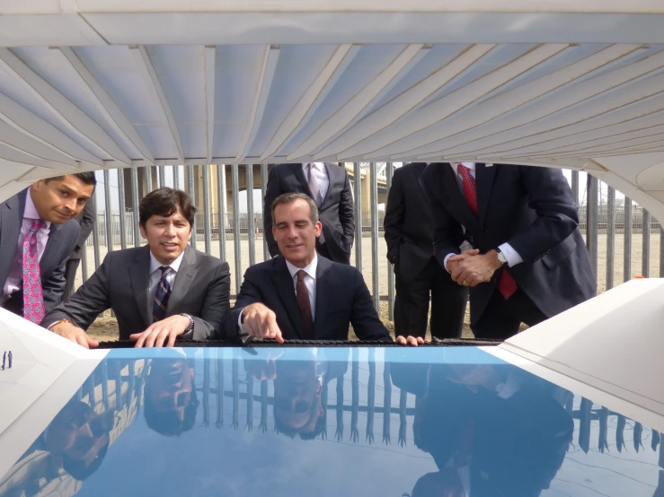 a group of men in suits standing by a pool