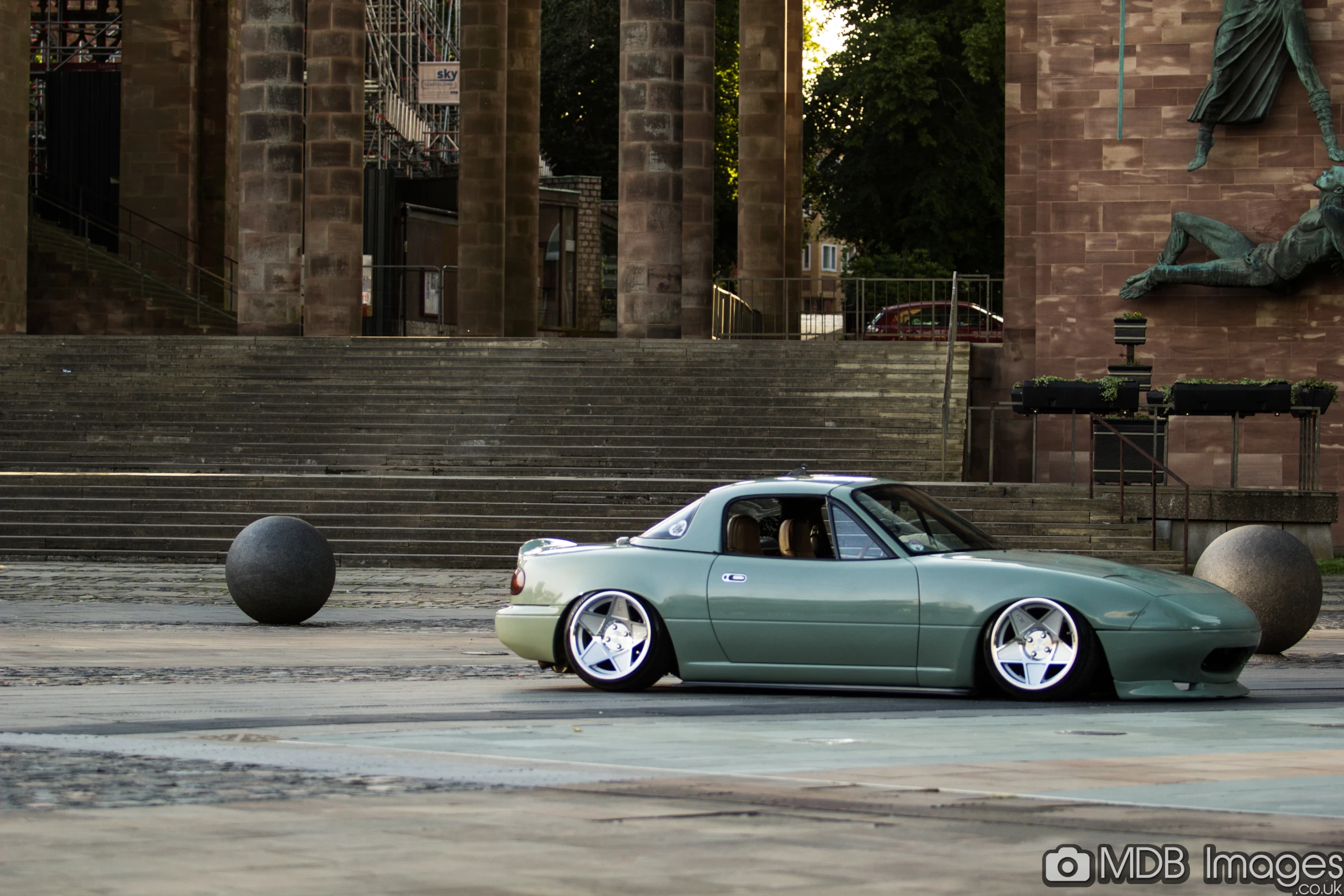 this green sports car is parked on the side of a street