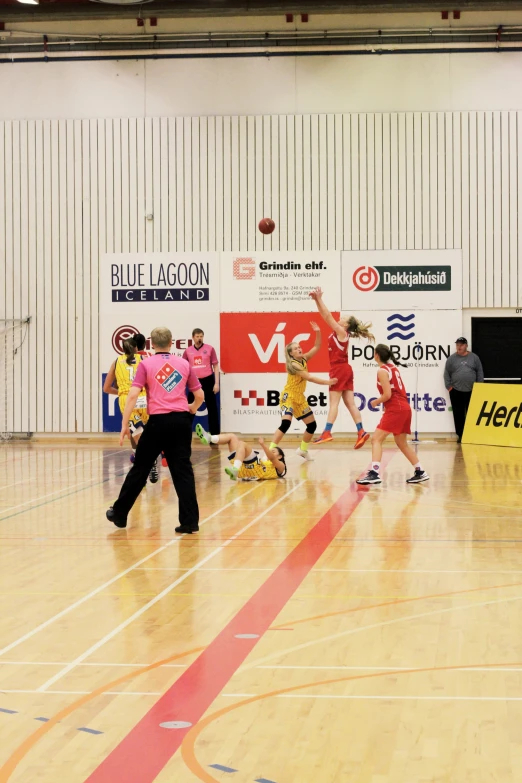 a girl in a pink shirt and red shorts is playing basketball