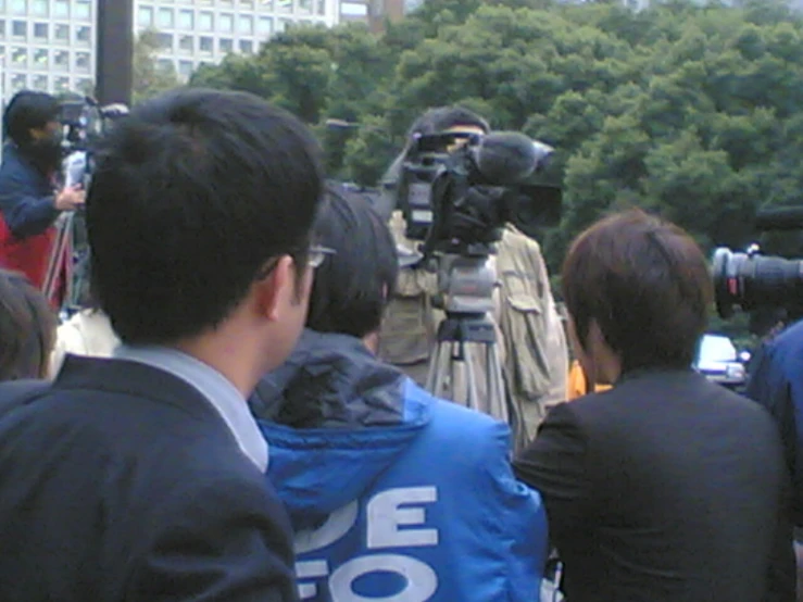 a man with a camera in front of a press team
