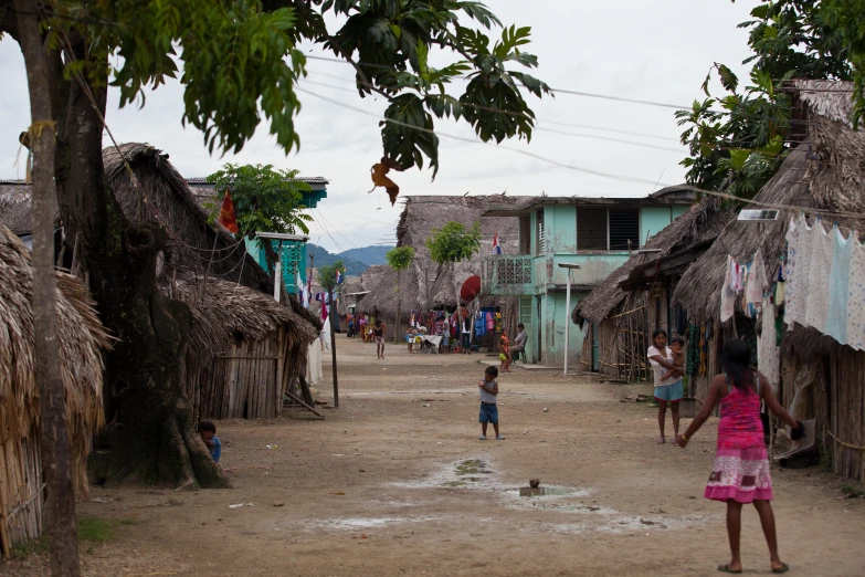 a group of people play a game of frisbee in a village