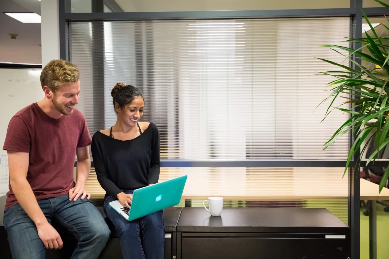 a man and a woman are working together in an office setting