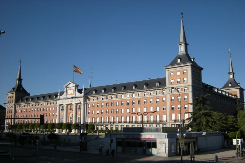 a large tan building has a spire on top