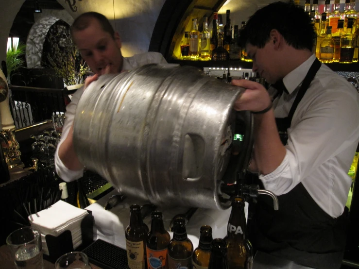 two men pouring drinks at a bar