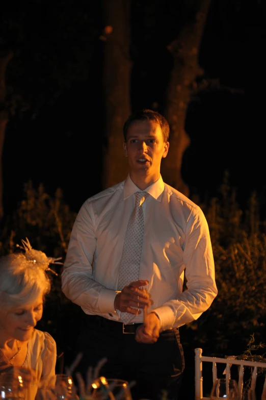 a man in white shirt and tie next to woman