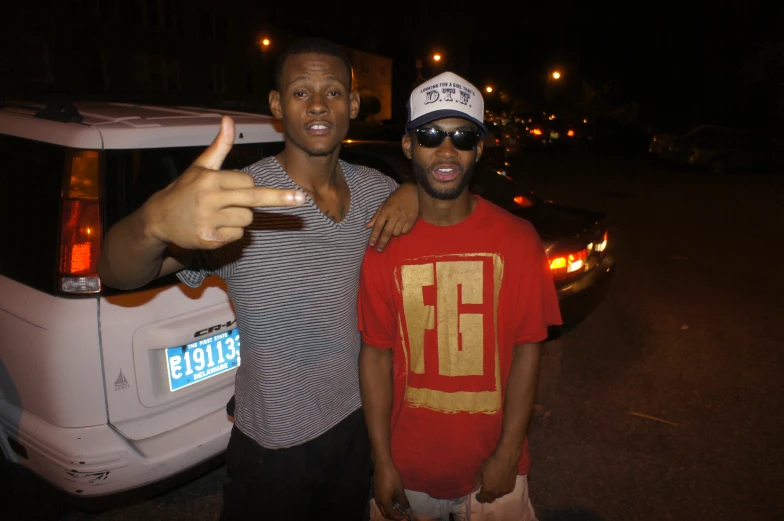 two men pose for a picture on the street