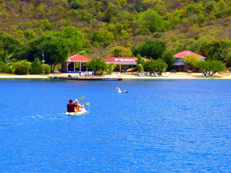 two people are in the water in their canoe