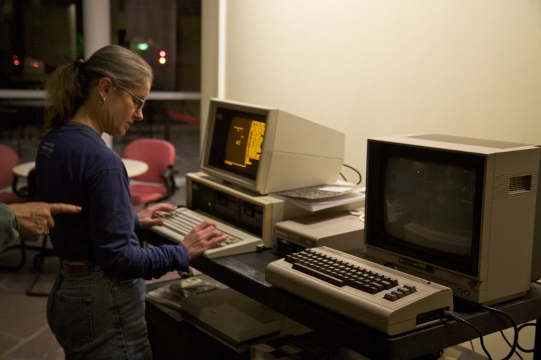 the woman is using her computer while on the desk