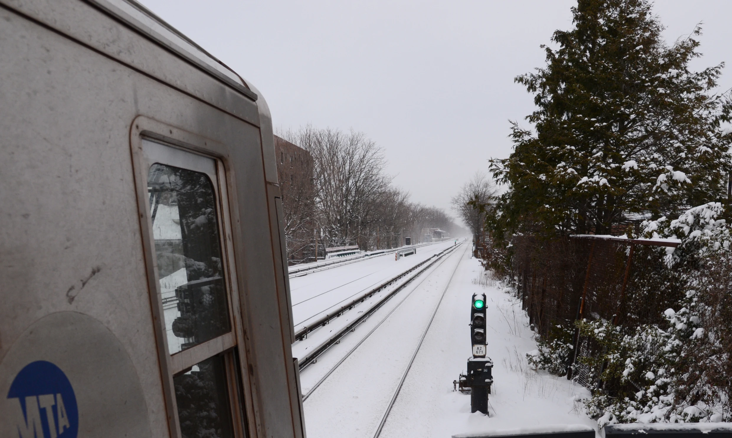 a train traveling down tracks next to trees in the snow