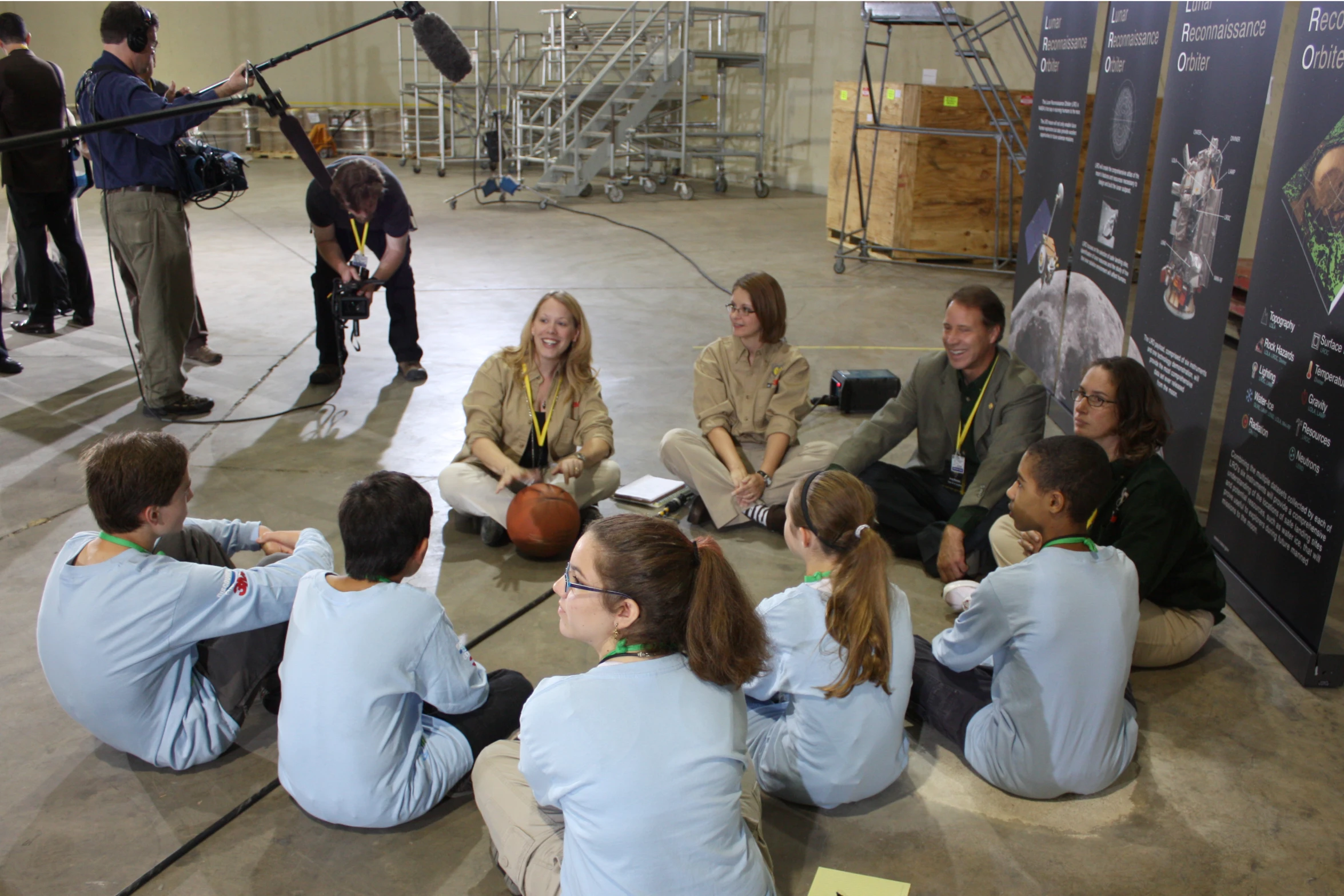 the group of young people are sitting in a circle together