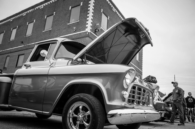 people in old cars are near an old brick building