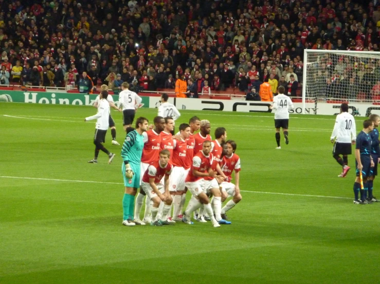 a group of players are on the field before a soccer match