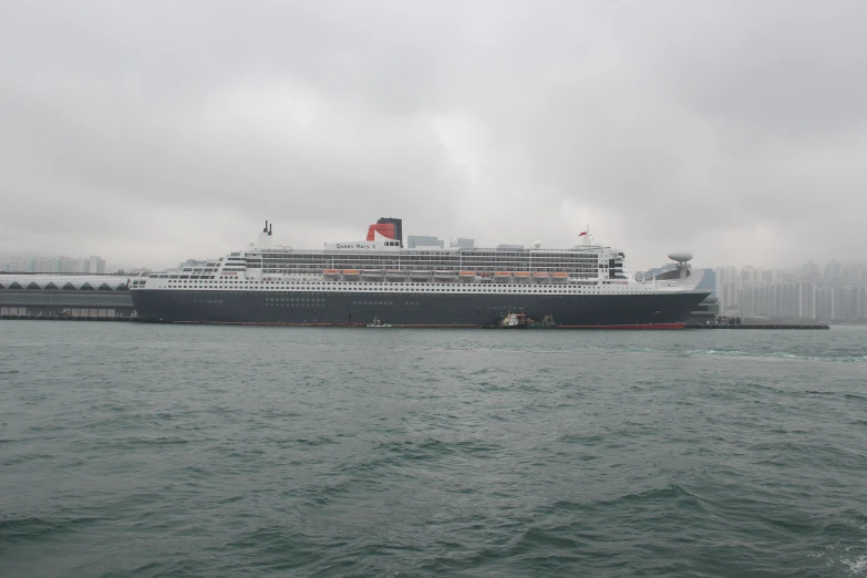 large passenger ship docked on the side of a body of water