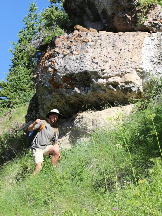 the man is walking uphill next to rocks