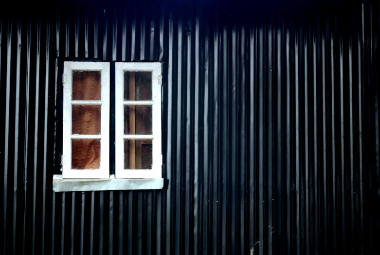 a red fire hydrant and white window in a dark building