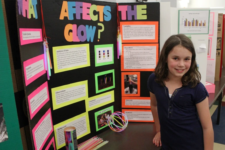 the girl is posing for a picture with her art class work