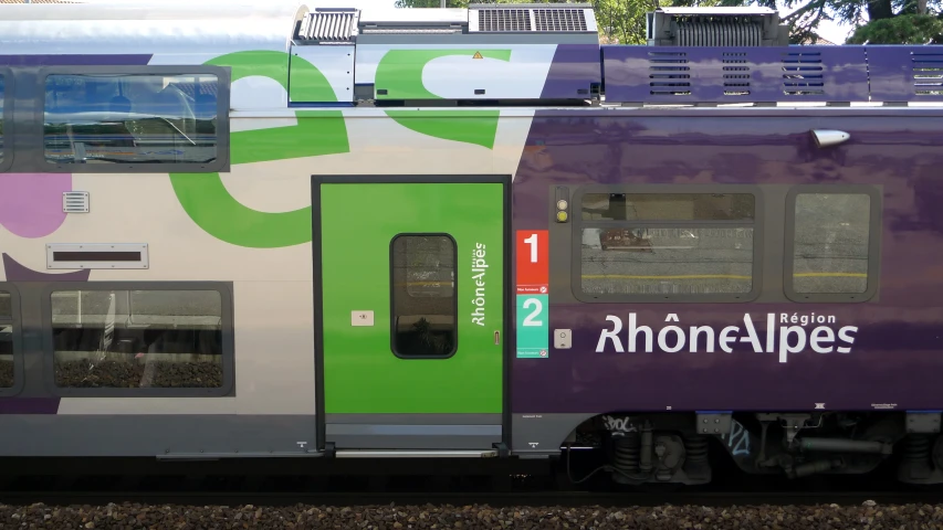 the large train has been painted a purple and green stripe