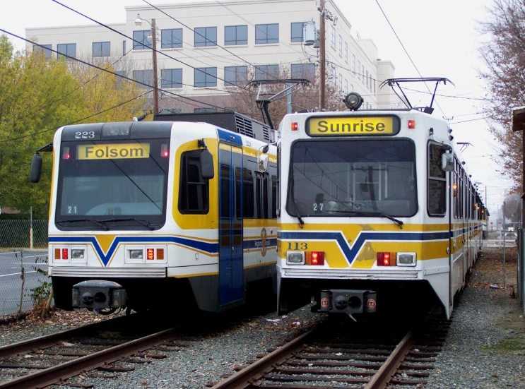 two commuter trains side by side on the tracks