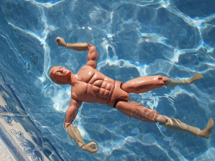 a doll laying in the water wearing scuba gear