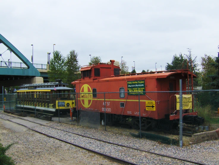 a train on tracks in front of a building and bridge