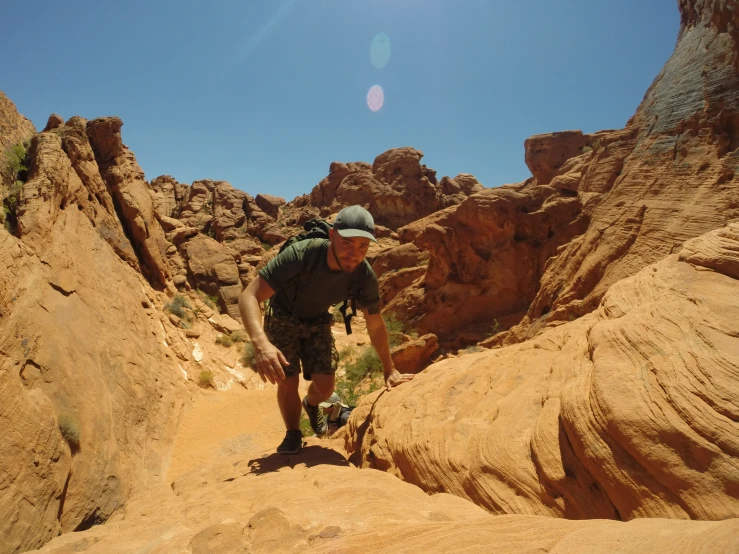 a man climbing up some cliffs in the desert