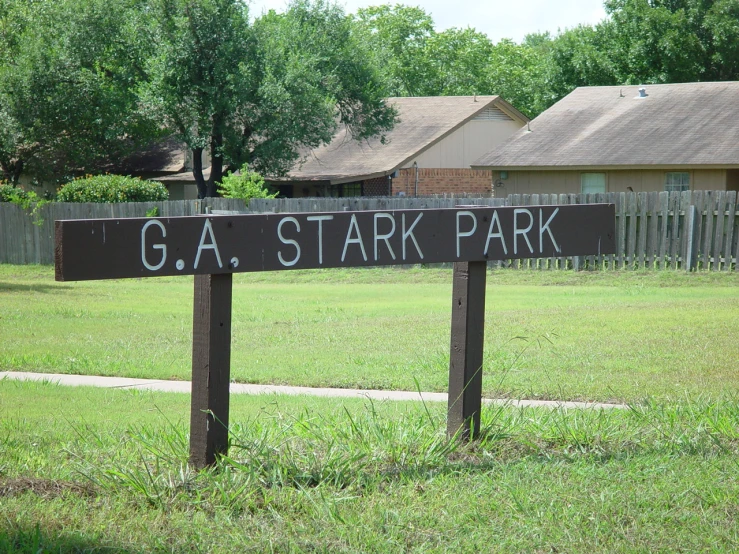 a wood street sign showing the name and location