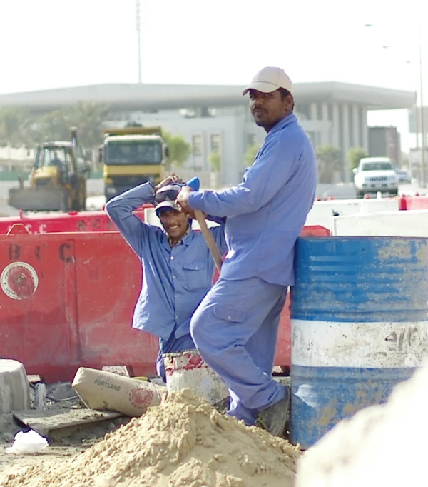 two men are fixing their hats in the sand