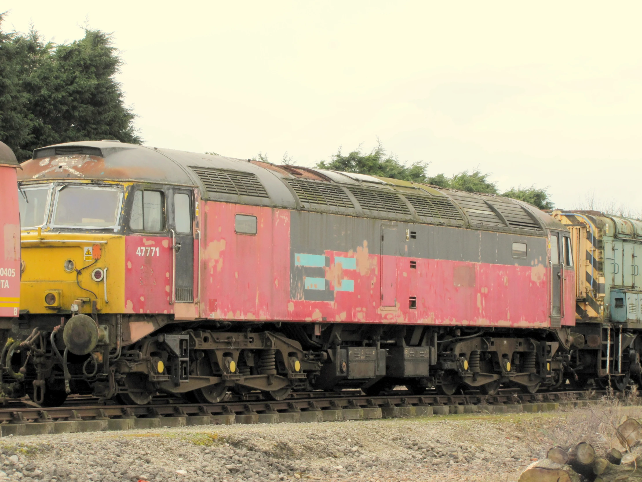 a long train parked on the tracks near trees