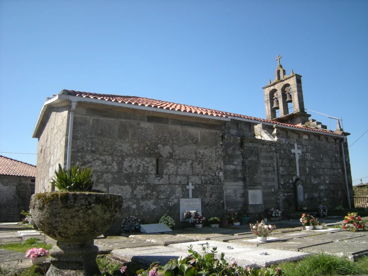 an old stone church with a steeple and a cross