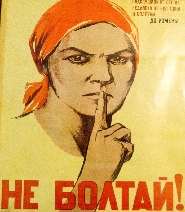 a poster with a person wearing a bandana holding a finger to her nose