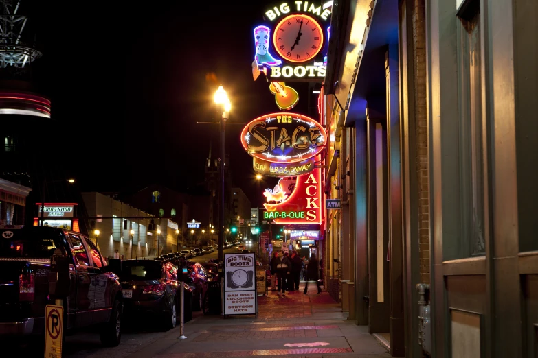 a street with various lighted signs and clock