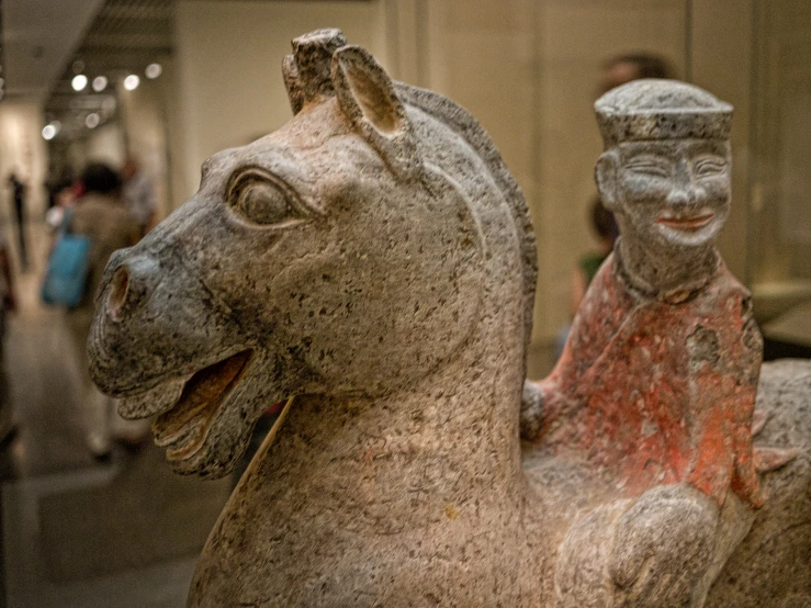 a close up s of two fake statues of a seated man and a horse