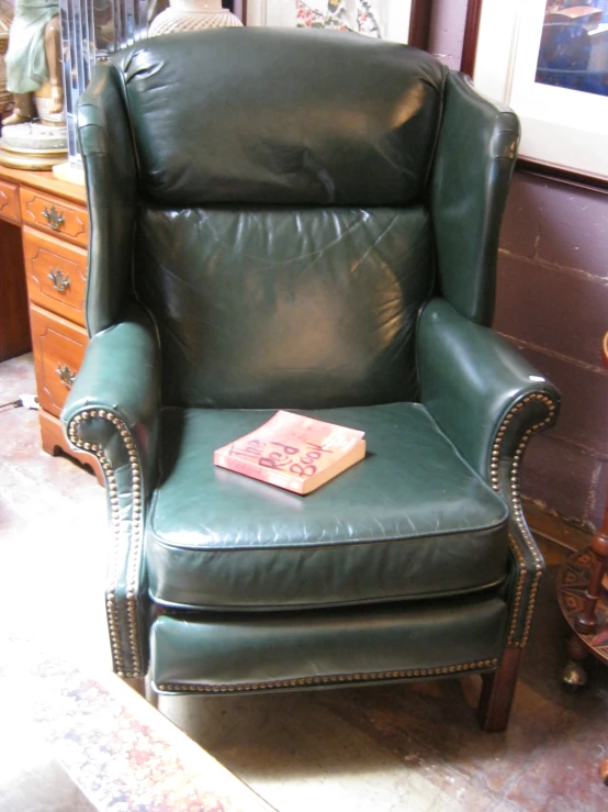 a leather recliner with a book on the arm