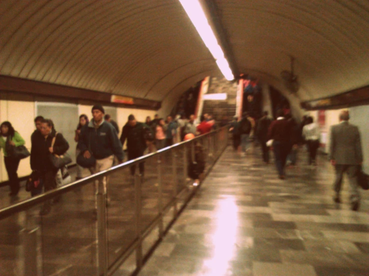 the people are walking by the moving subway car