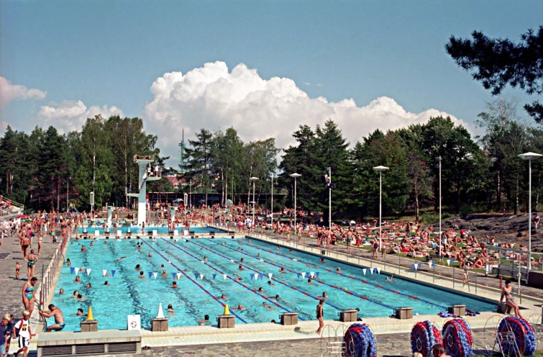 a big swimming pool with several people standing around