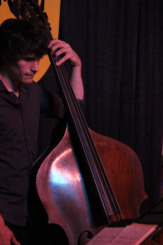 a man wearing a black shirt is holding a bass