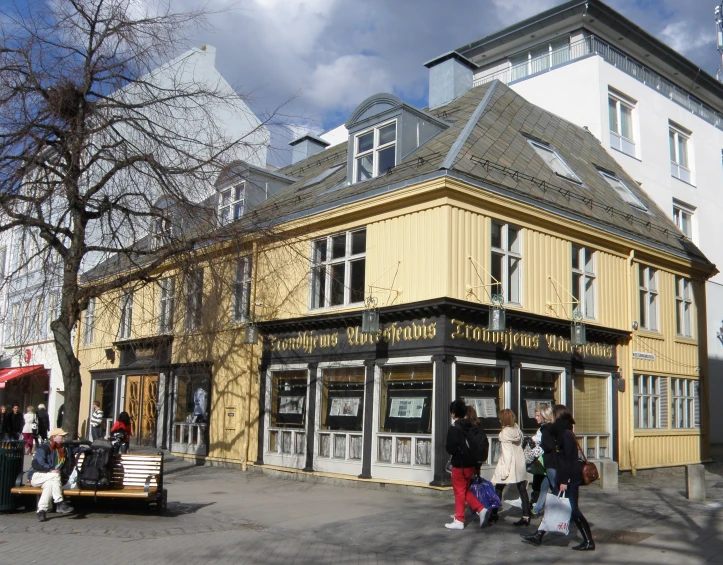 a large yellow building with people standing outside