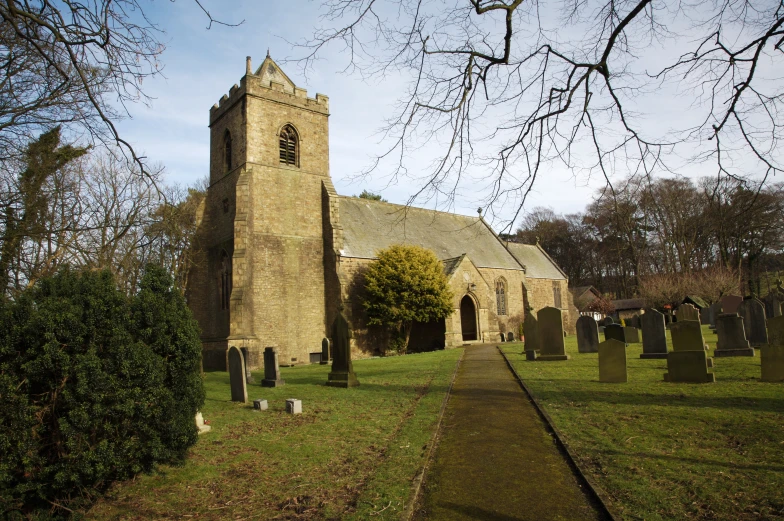 a big church with a tall tower near a cemetery