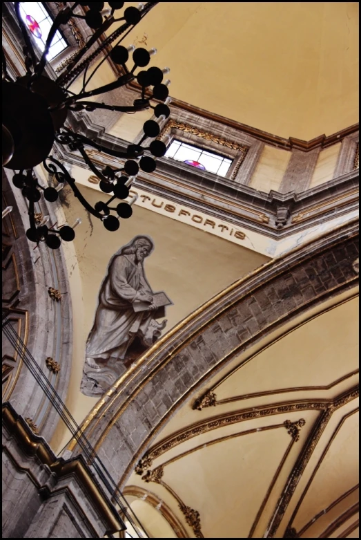 statue in center of church with light coming through window