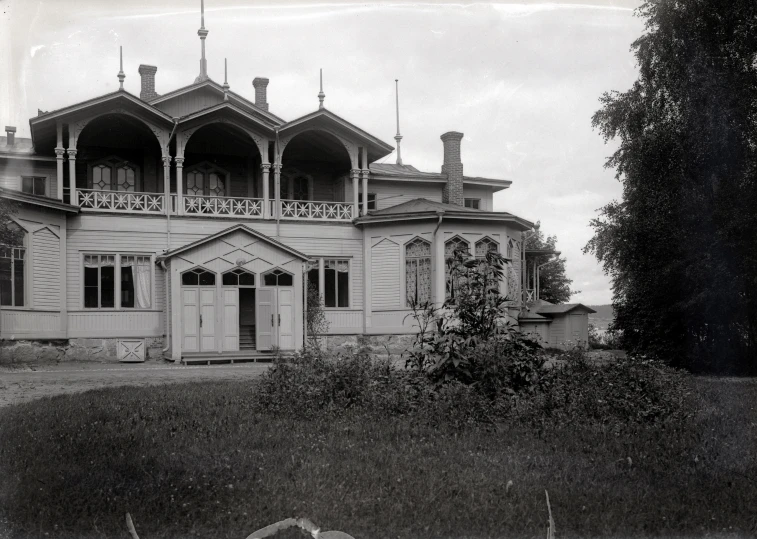 an old white house with tall towers and a large clock