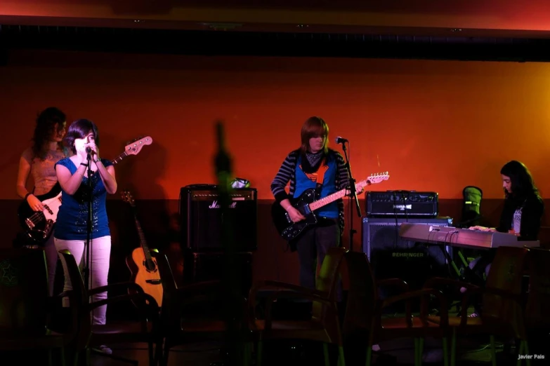 a band playing music in the dark by a table