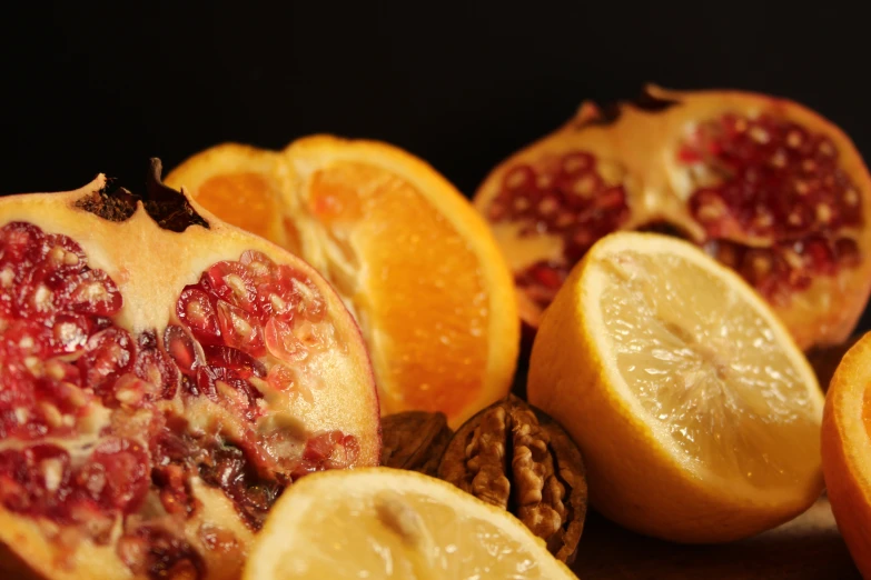 sliced oranges and pieces of pomegranate displayed on surface