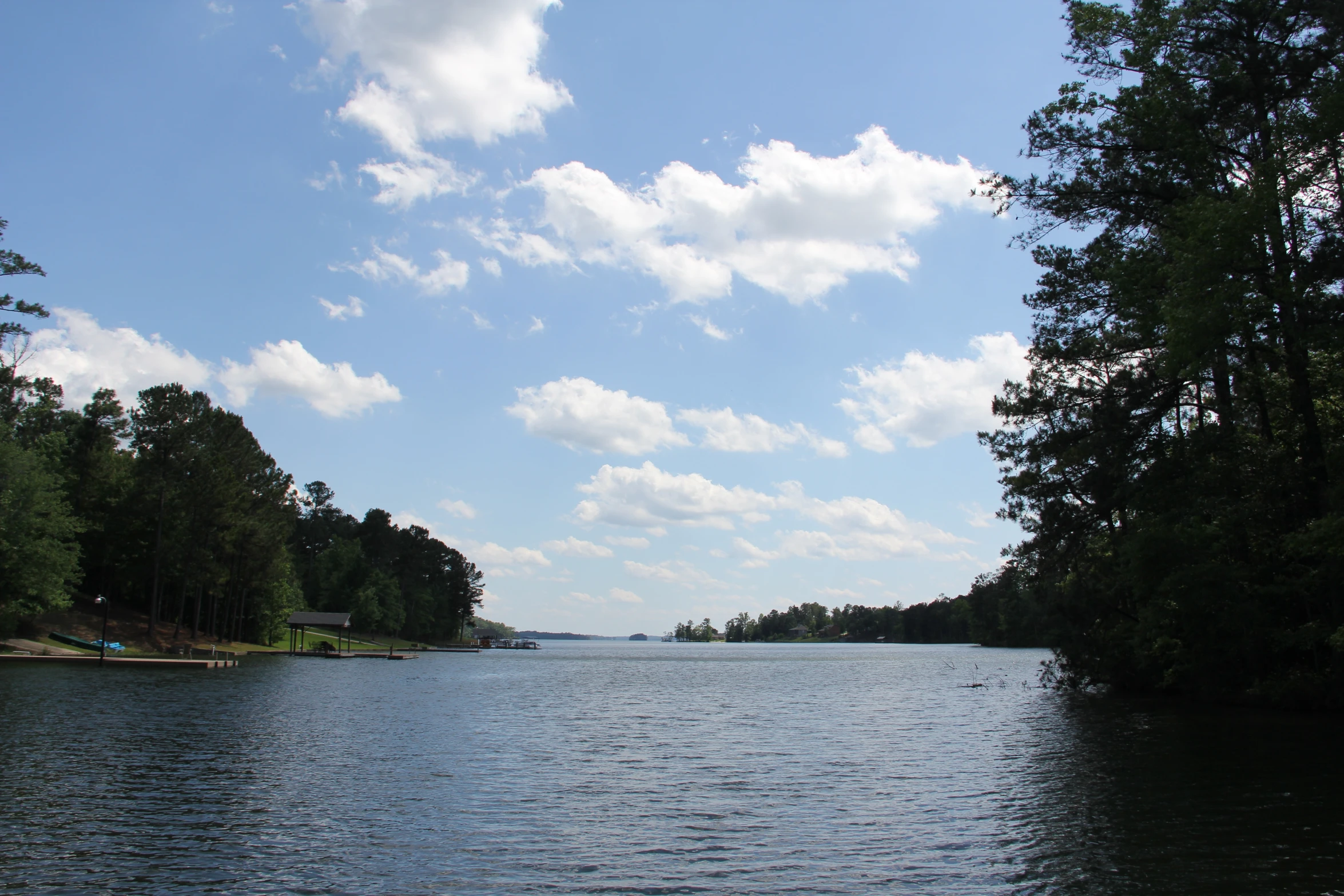 a wide river surrounded by trees on a sunny day