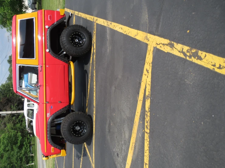 a red car with yellow trim in a parking lot