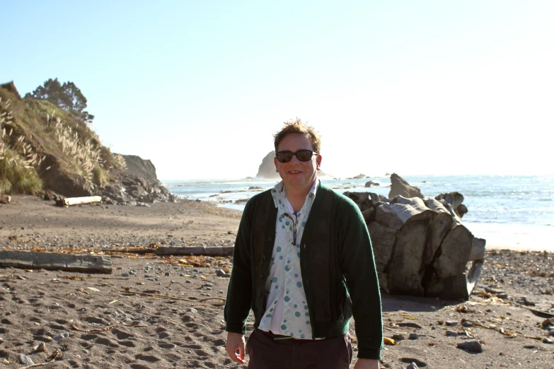 a man walking on a beach near the ocean