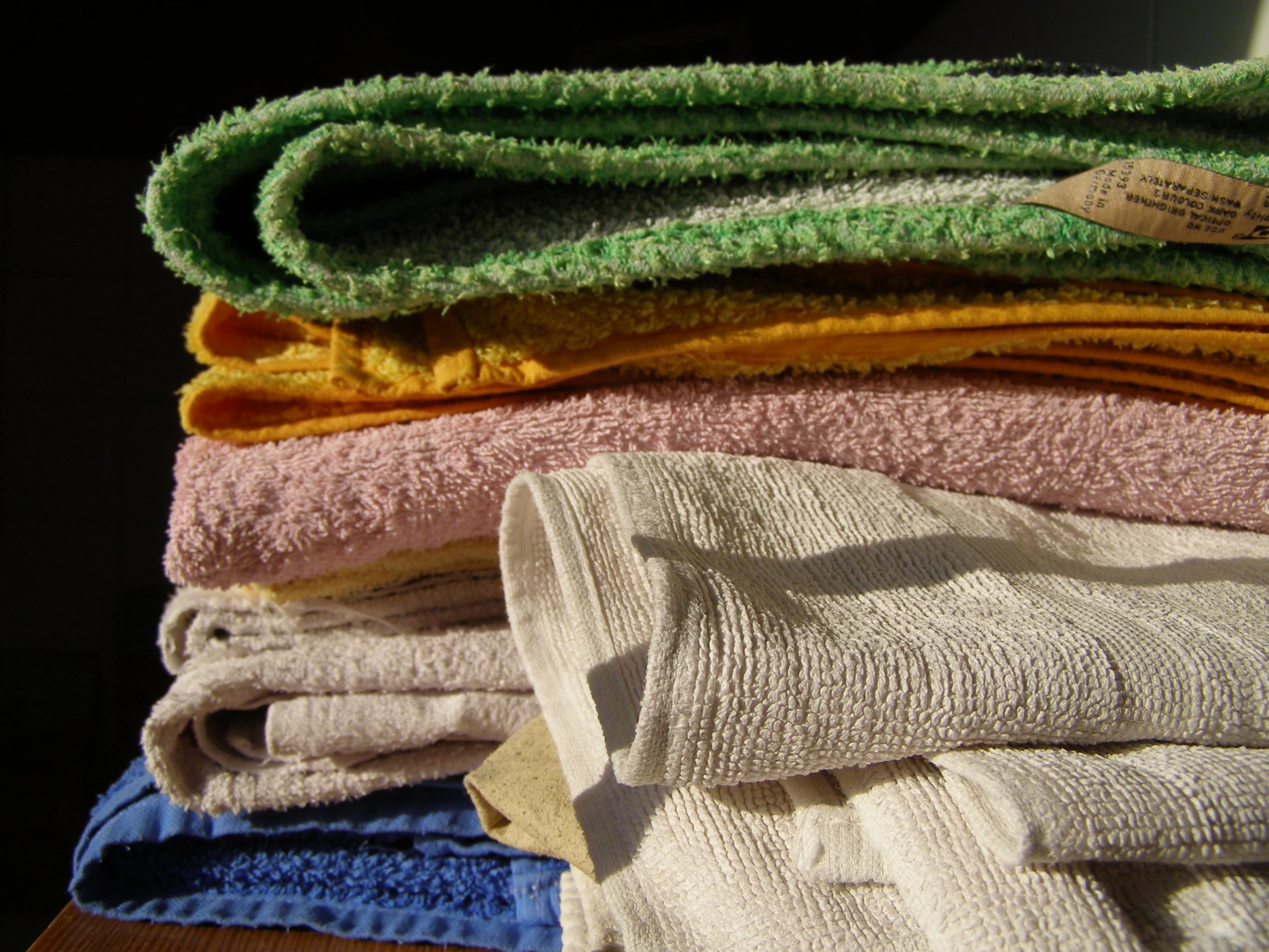 stack of folded towels and some folded one sitting next to another