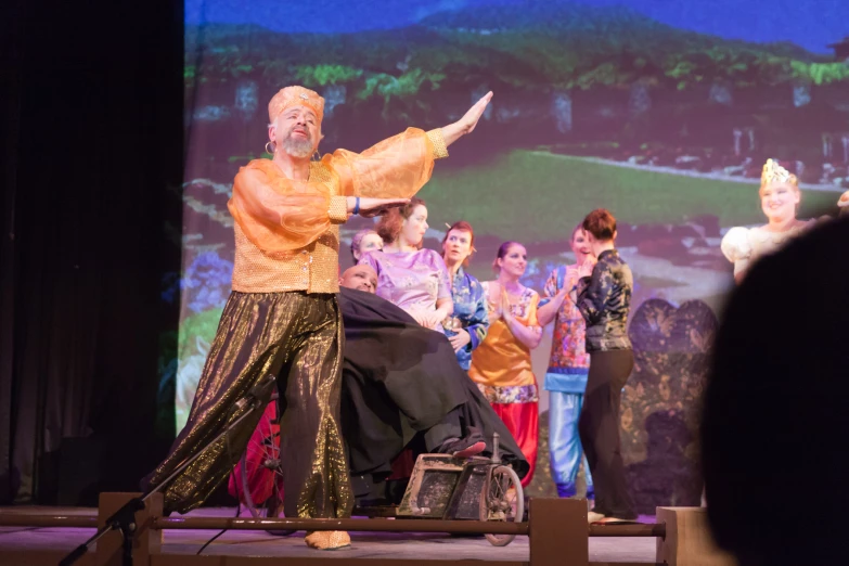 people in an audience clapping and dancing on a stage