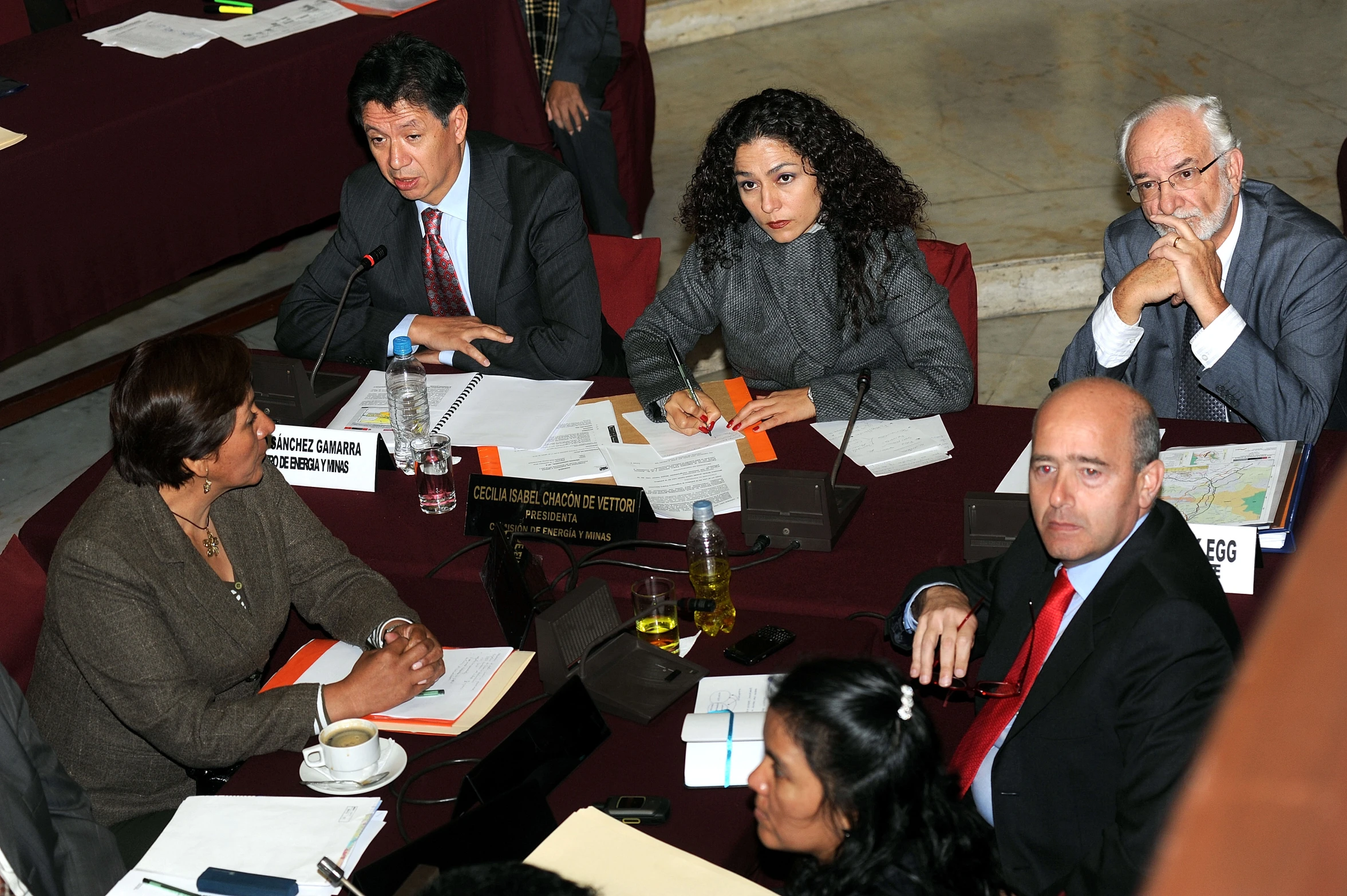 a group of people sit in chairs at tables working